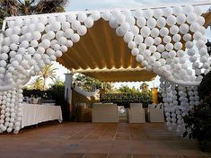 an outdoor dining area decorated with white balloons