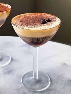 two glasses filled with dessert sitting on top of a table