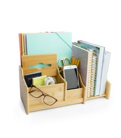 a wooden desk organizer with glasses, notebooks and other office supplies in it on a white background