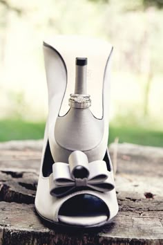 a wine bottle holder with a bow tie on top of it, sitting on a piece of wood