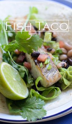 fish taco with black beans, avocado and cilantro on a plate