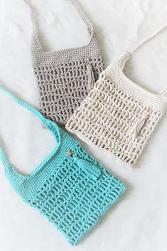 three crocheted purses sitting on top of a white bed next to each other