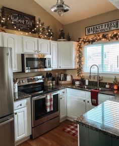 a kitchen with white cabinets and christmas decorations