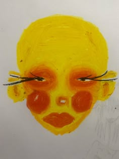 a child's face painted with yellow and orange paint on white paper next to a drawing of a woman's face