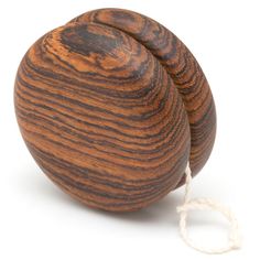 a ball of wood sitting on top of a white string next to a wooden object