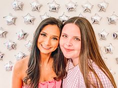 two young women are posing for a photo in front of star shaped wallpapers