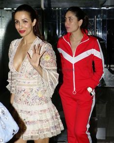 two women in red and white outfits standing next to each other with their hands together