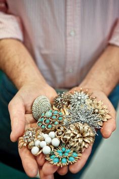 a person holding several different types of brooches in their hands, all together