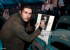 a man is holding up a photo in the stands