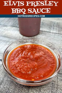 a glass bowl filled with bbq sauce on top of a wooden table