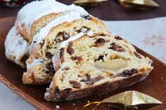 some type of bread with icing and chocolate chips on the side sitting on a wooden platter