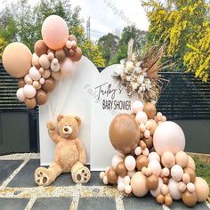 a teddy bear sitting next to balloons and a sign that says, baby showerer