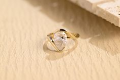 a diamond ring sitting on top of a table next to a piece of white paper