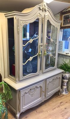 an antique china cabinet with glass doors in a living room