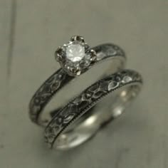 two silver rings with a diamond in the middle