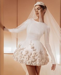 a woman in a short white dress and veil