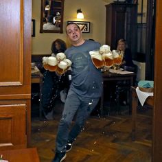 a man is jumping in the air with beer glasses