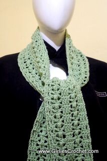 a green crocheted scarf on top of a mannequin