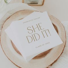 a stack of white cards sitting on top of a wooden plate next to a vase