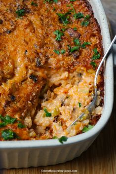 a casserole dish with meat and vegetables in it is being eaten by a fork