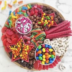 an assortment of candies, candy and lollipops arranged on a plate