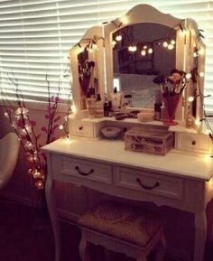 a vanity with lights on it in front of a window