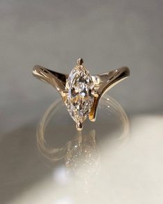 a diamond ring sitting on top of a white surface with light reflecting off it's side