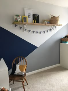 a room with a chair, shelves and pictures on the wall in it's corner