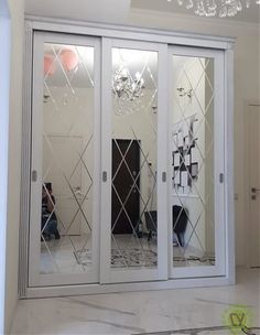 a white room with mirrored doors and chandelier