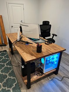 a computer desk with a fish tank on it