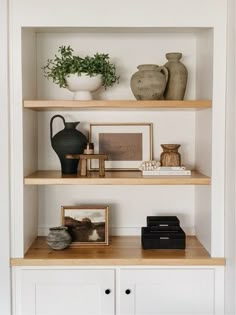 some shelves with vases and pictures on them