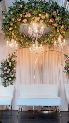 a white couch sitting under a chandelier covered in flowers