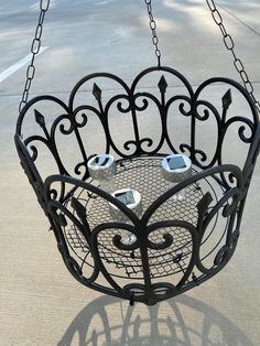 a black metal hanging basket with two cups on it