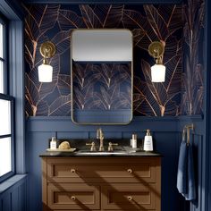 a bathroom with blue and gold wallpaper, two sinks and a large mirror on the wall