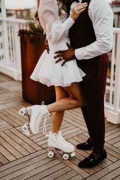 a man and woman on roller skates posing for the camera with their arms around each other