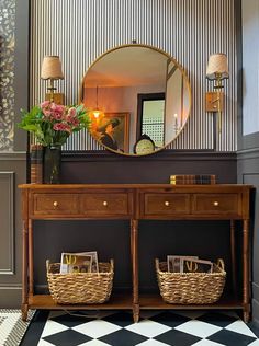 an entryway with a checkered floor and wallpaper on the walls, two wicker baskets under a mirror