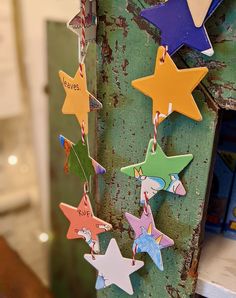 three wooden stars hanging from a green pole