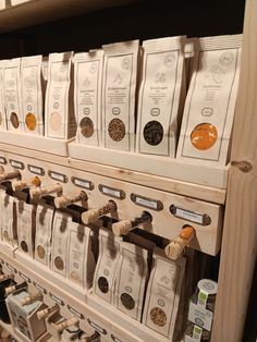 the shelves are filled with different types of coffee beans and tea bags on wooden racks