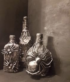 three glass bottles sitting on top of a shelf