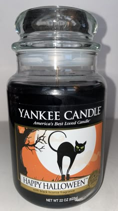 a jar of yankee candle with a black cat on it's lid and the words happy halloween