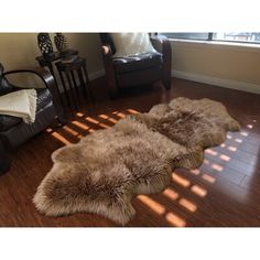 two sheepskin rugs sit on the floor in front of a chair and window