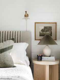 a bedroom with a bed, lamp and pictures on the wall above it's headboard