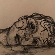 a pencil drawing of a woman's head resting on the ground