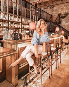 a woman sitting at a bar talking on the phone