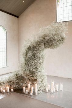 an artistic display of candles and flowers in a church