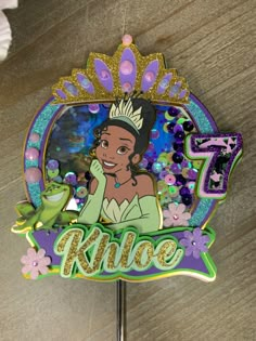 a cake topper with the name and image of a princess on it's face