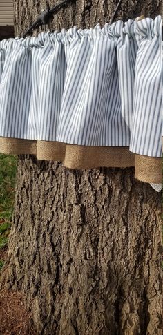 blue and white striped curtains hanging from a tree