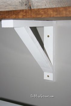 an unfinished shelf with two brackets on it