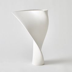 a white vase sitting on top of a table