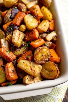 a white casserole dish filled with roasted vegetables